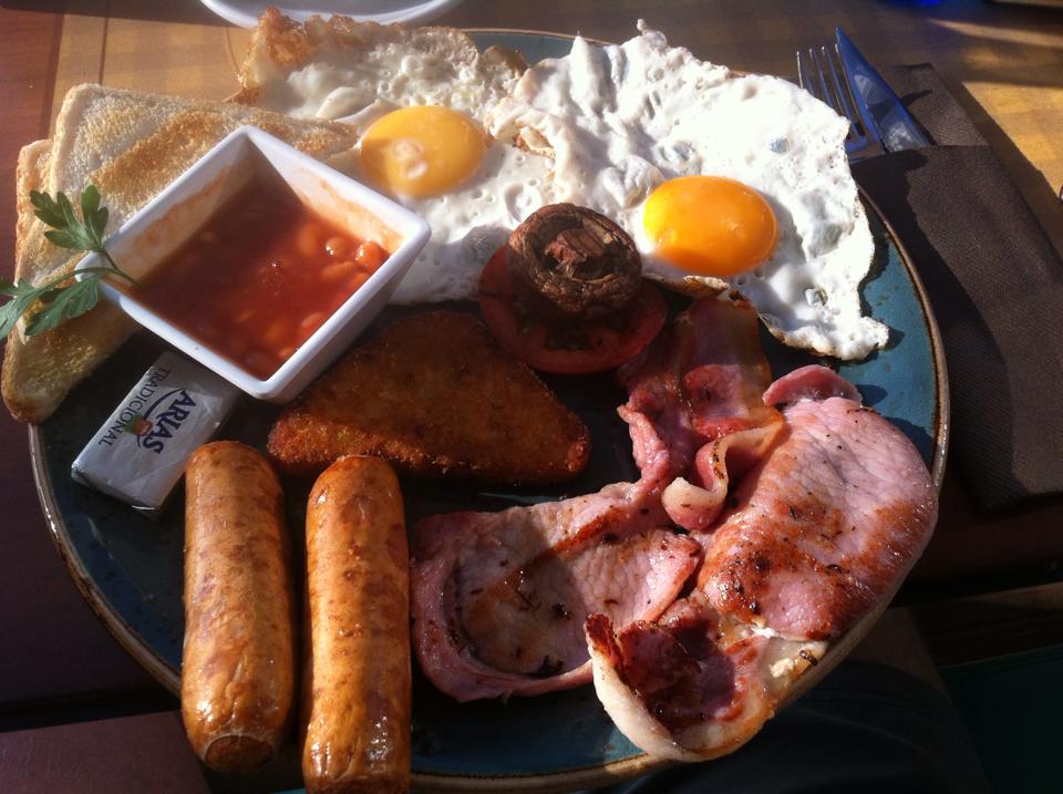 A cooked breakfast with eggs, bacon, sausages, beans and toast at Somewhere Different